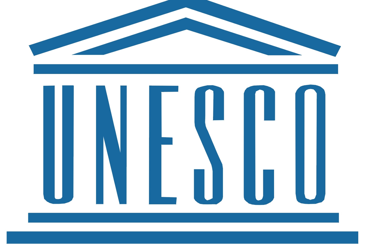 UNESCO logo in blue with a stylized roof motif above and lines framing the word UNESCO