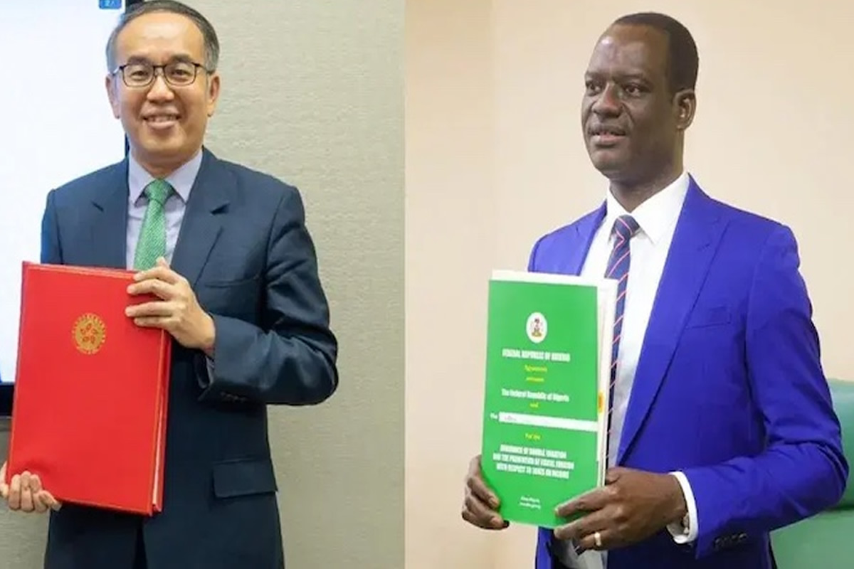 Two men in suits stand side by side, each holding a large colorful folder (red on the left, green on the right).