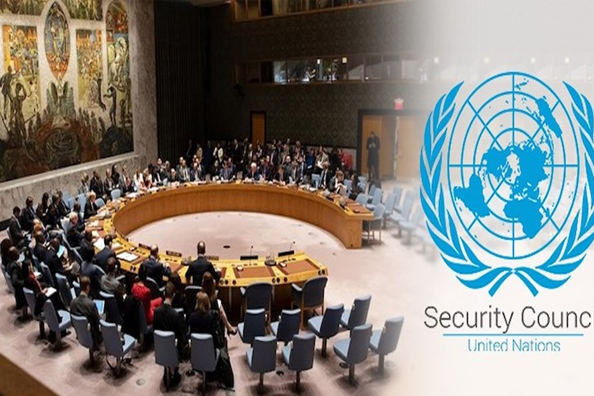 United Nations Security Council meeting around a large circular table with delegates seated; UN emblem on the right.