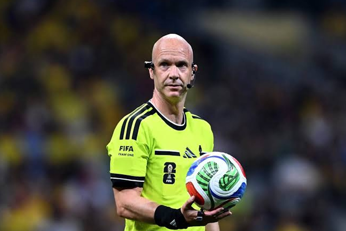 Male soccer referee in a neon yellow kit holding a colorful FIFA match ball during a game.