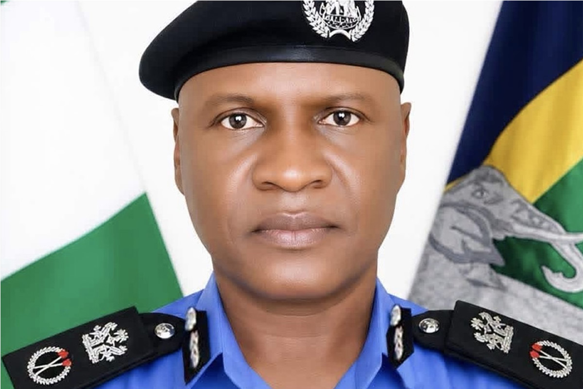 Portrait of a police officer in a blue uniform and black beret, with a flag in the background representing service and duty.