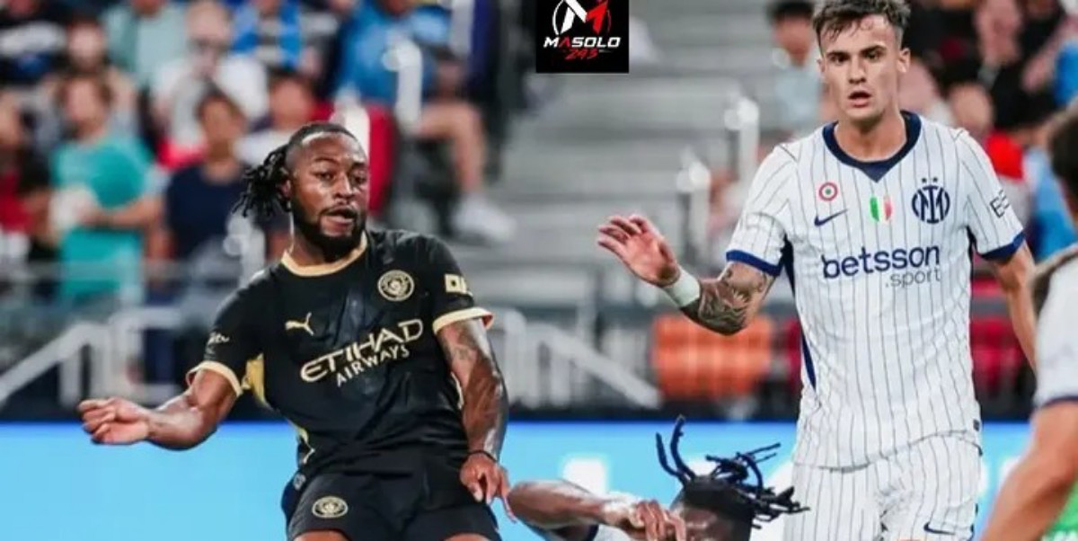 Two soccer players chase the ball during a match; one in black and gold kit, the other in a white pinstripe kit.