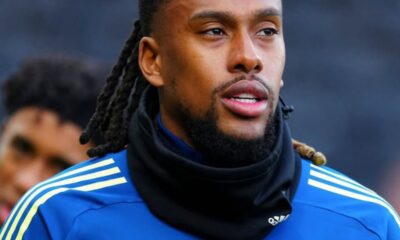 Footballer in blue training jersey with crest and number 17, wearing a black neck warmer, outdoors during training.