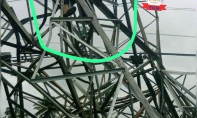 Damaged metal transmission tower with bent and tangled steel beams circled in green