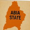 Orange silhouette of Abia State with the label ABIA STATE over it on a beige background