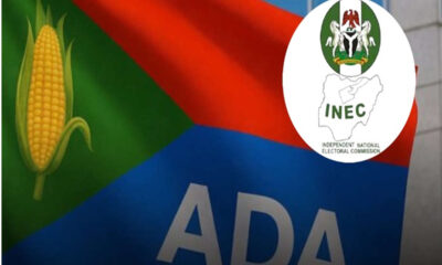 Campaign sign featuring the letters 'ADA' on a blue panel with a corn icon on the left and an INEC emblem overlay on the right.