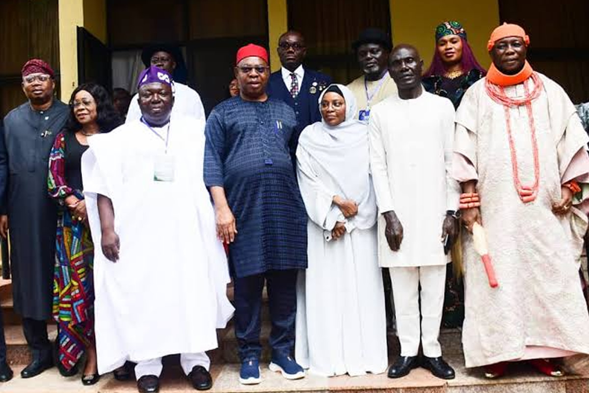 Group of people in traditional Nigerian attire posing on steps for a formal group photo.