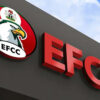 EFCC sign on a dark wall with a circular logo featuring an eagle, Nigeria’s crest, and bold red letters EFCC