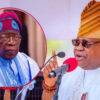 Man in white agbada and gold-striped hat speaks into a red microphone; an inset shows an older man in blue attire and cap.