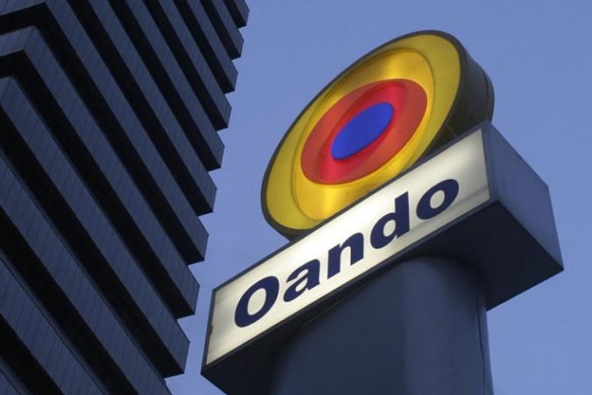 Oando company sign with a circular yellow-red-blue logo against a blue sky