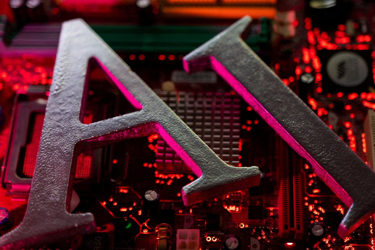 Close-up of large gray metal letters forming 'AI' on a red-lit computer motherboard.