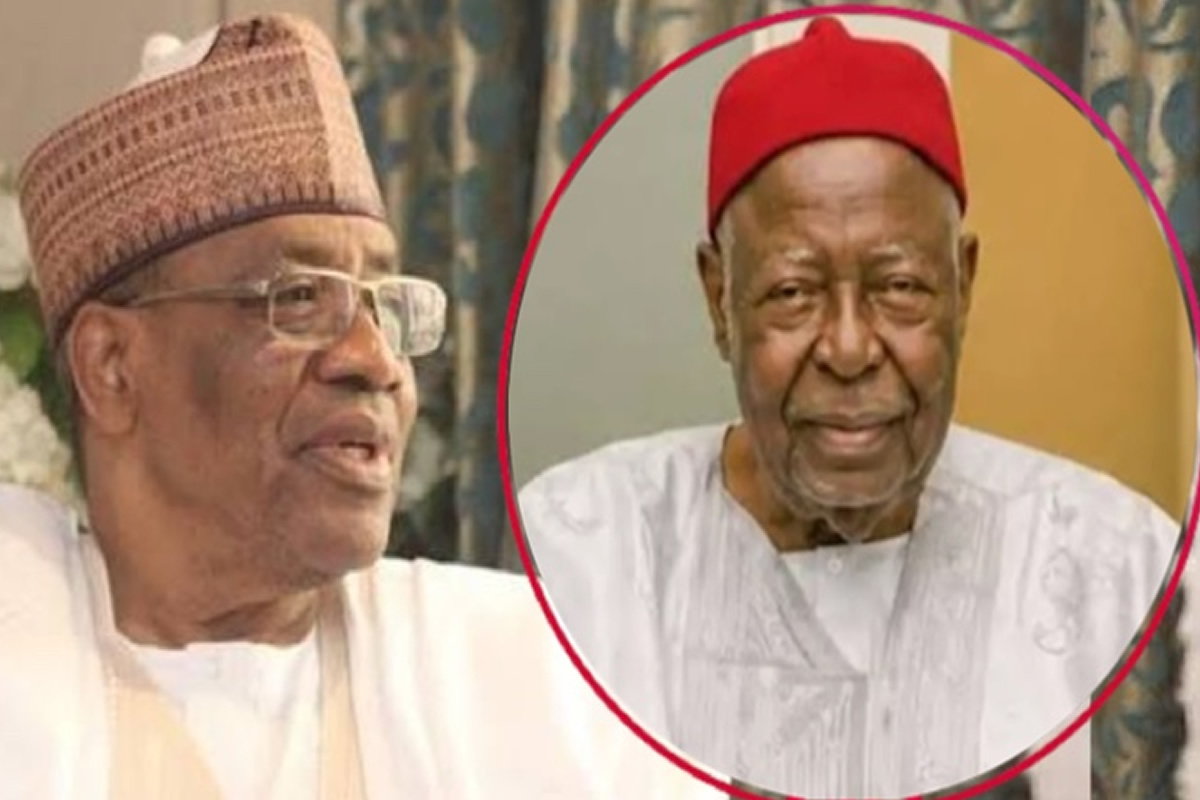 Two elderly men in traditional West African attire; left man wears glasses and a patterned cap, right man in a red fez-style hat inside a pink circle